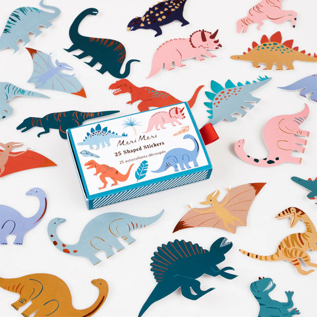Meri Meri dinosaurus stickers in verschillende kleuren en vormen, verspreid rondom de geopende verpakking.
