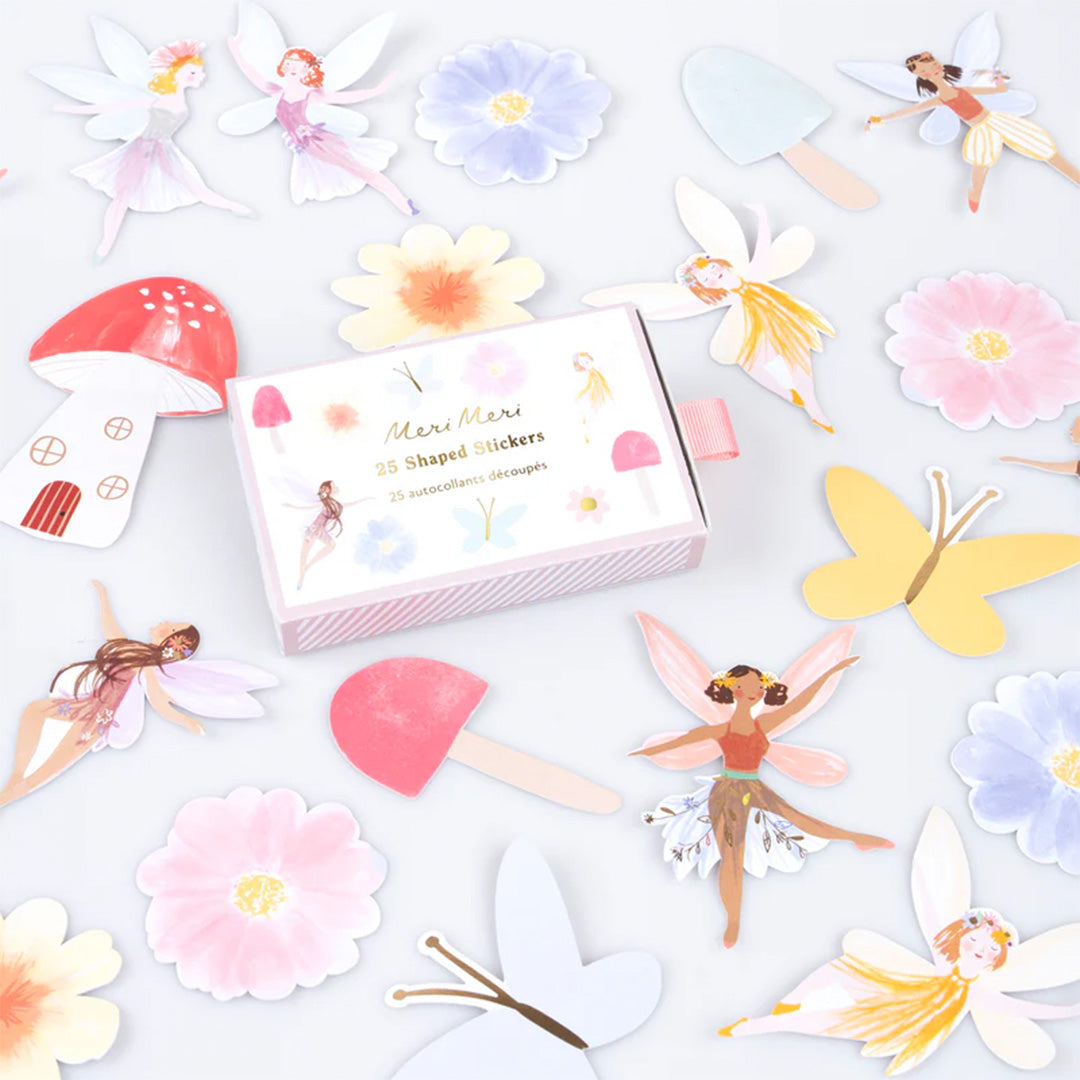 Meri Meri gevormde stickers met feeën, bloemen, vlinders en paddenstoelen, verspreid rond de verpakking.