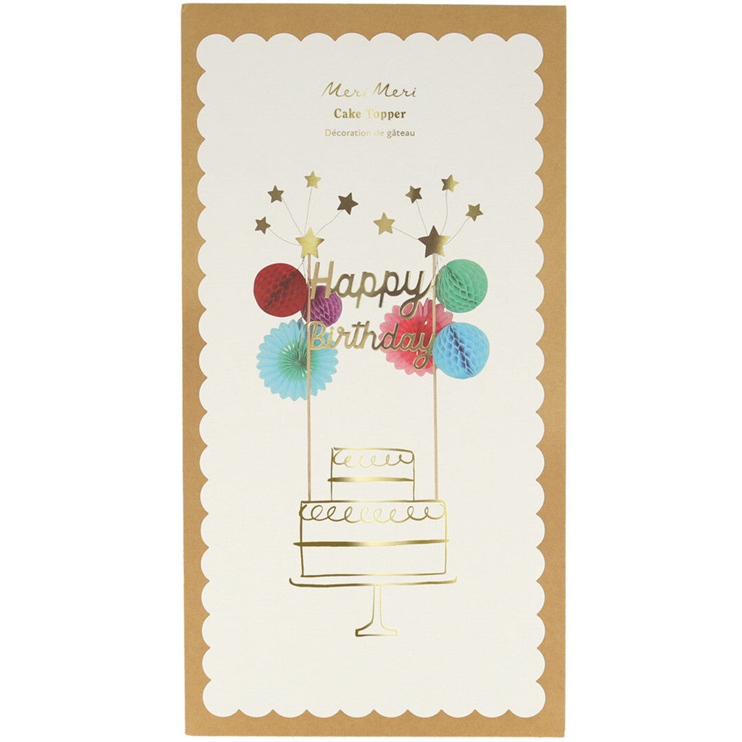 Verpakking van de Meri Meri Happy Birthday taarttopper met een illustratie van een taart.