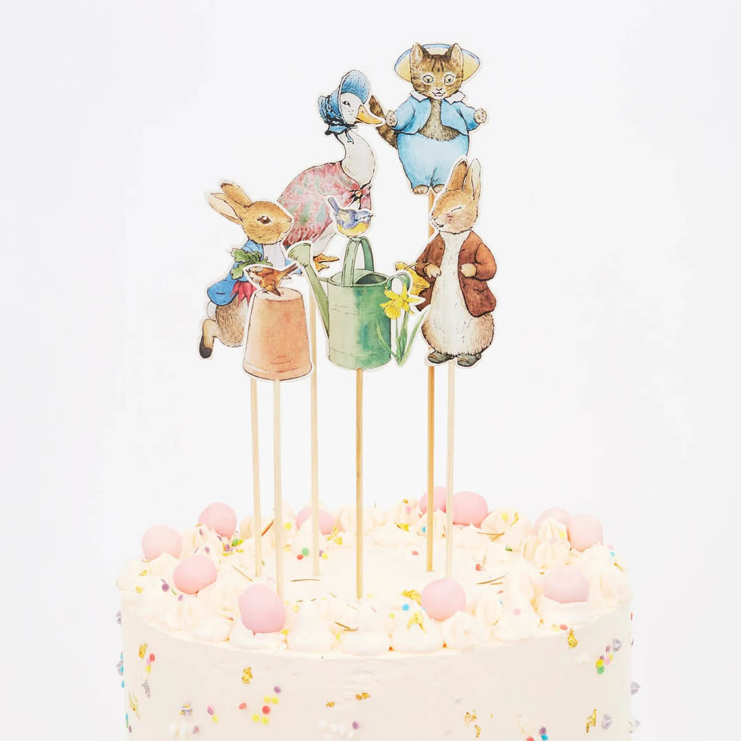 Peter Rabbit cake toppers met dierenfiguren op een witte taart.