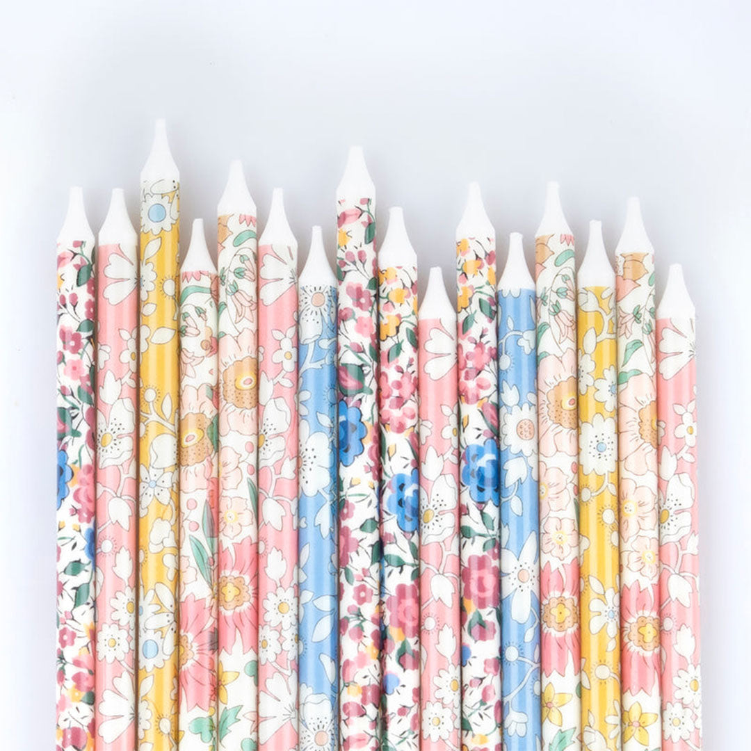 Een rij Meri Meri verjaardagskaarsen met veelkleurige bloemmotieven in detail.