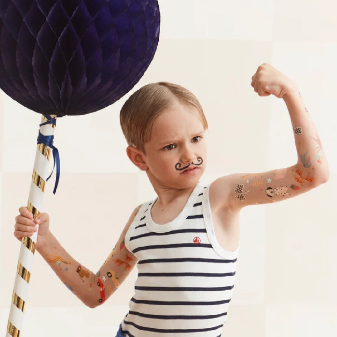 Jongen met een snor en Meri Meri tijdelijke raceauto tatoeages op zijn armen.