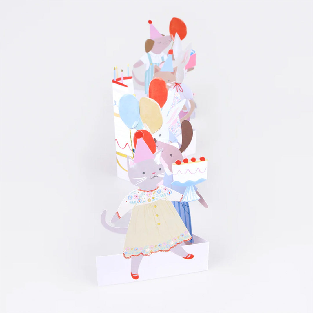 Meri Meri pop-up verjaardagskaart schuin van bovenaf gezien, met een kat die een taart vasthoudt.
