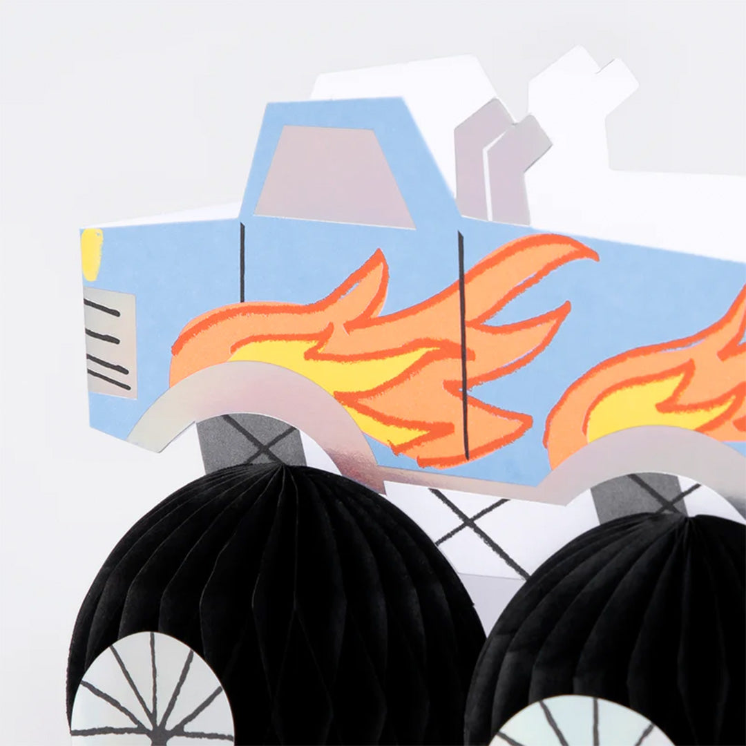 Detail van de Meri Meri verjaardagskaart met de voorkant van een blauwe monster truck en een zwart honingraatwiel.