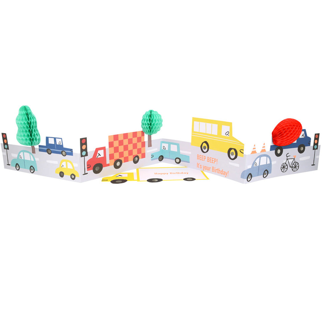 Meri Meri transport verjaardagskaart uitgevouwen met een wegscène vol voertuigen en pop-up bomen.