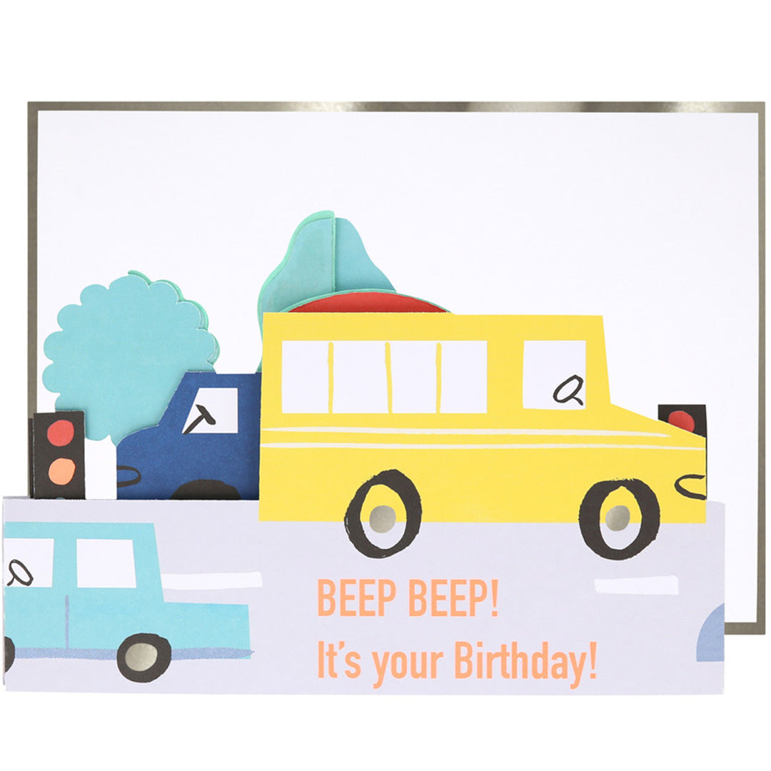 Detail van de Meri Meri transport verjaardagskaart met een gele schoolbus, blauwe vrachtwagen en de tekst 'BEEP BEEP! It's your Birthday!'.