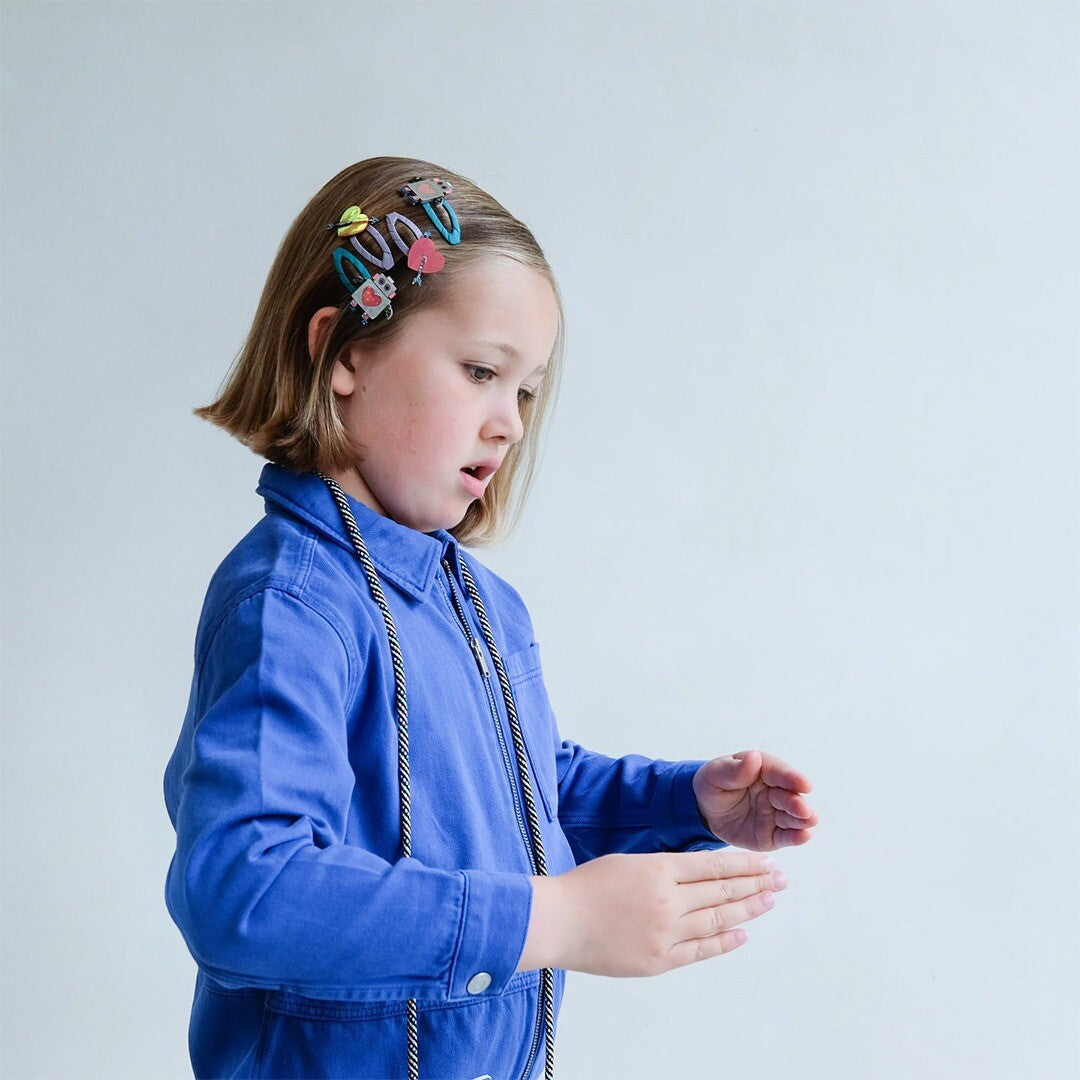 Een kind met diverse haarspeldjes in het haar, als demonstratie van het product.