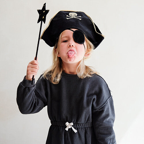 Een kind met de mimi & lula piratenhoed en ooglapje steekt de tong uit en houdt een sterrenstaf vast.