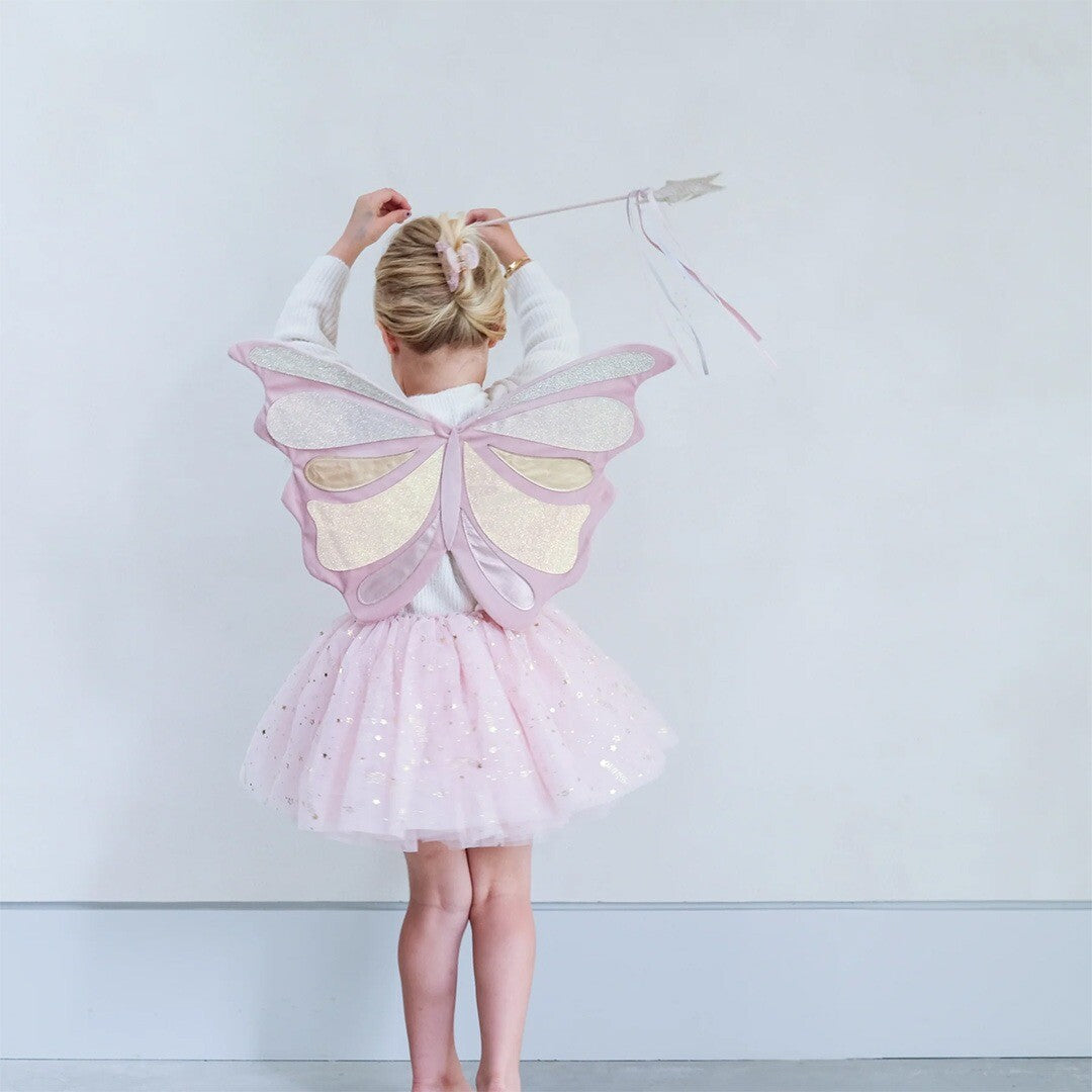 Meisje van achteren met roze vlindervleugels en een roze tutu.