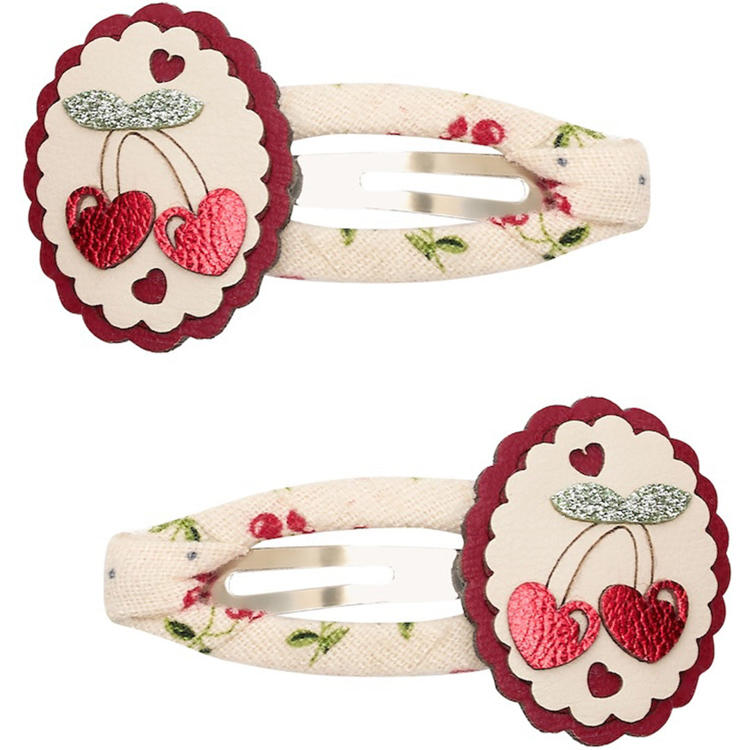 Twee mimi & lula haarspeldjes met beige stof, bloemenpatroon en rode hartjes die op kersen lijken.