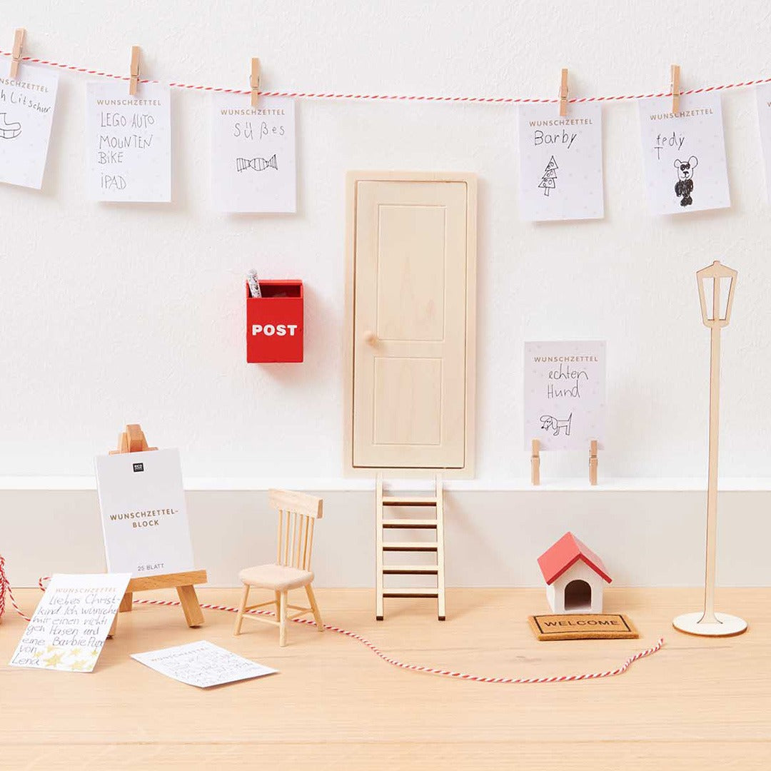 Rico Design miniatuur houten stoel in een poppenhuisdecor met diverse accessoires.