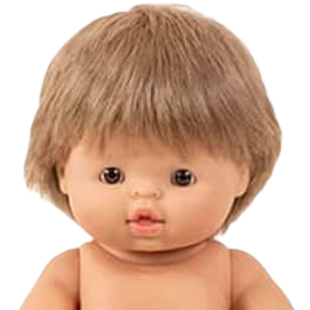 Close-up van het gezicht van de Minikane babypop Achille met lichtbruin haar.