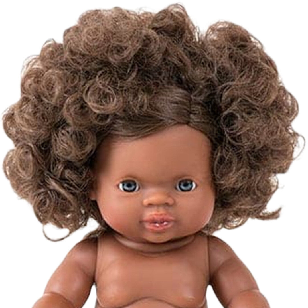 Close-up van het gezicht van Minikane babypop Charlie met krullend bruin haar en blauwe ogen.