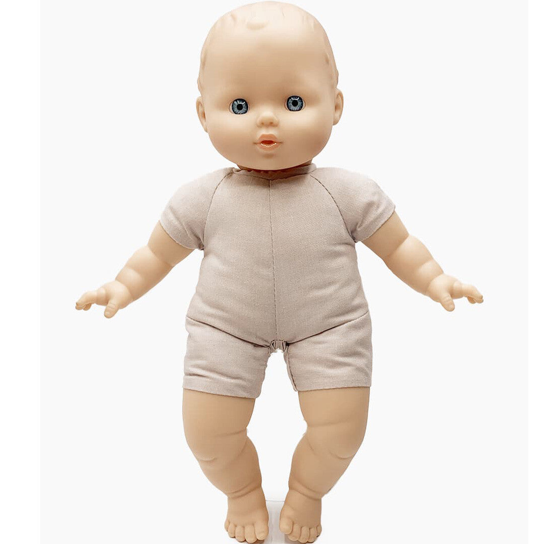 Paola Reina babypop Claire met vinyl hoofd, armen en benen en een stoffen lijfje in een beige pakje.