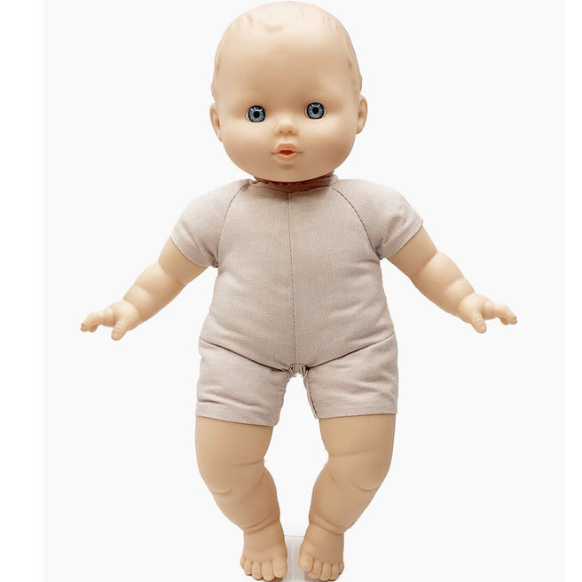 Paola Reina babypop Claire met vinyl hoofd, armen en benen en een stoffen lijfje in een beige pakje.