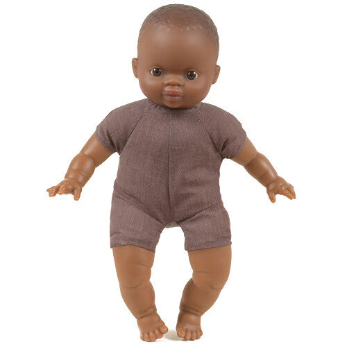 Paola Reina babypop met donkere huidskleur en bruine romper, staand.