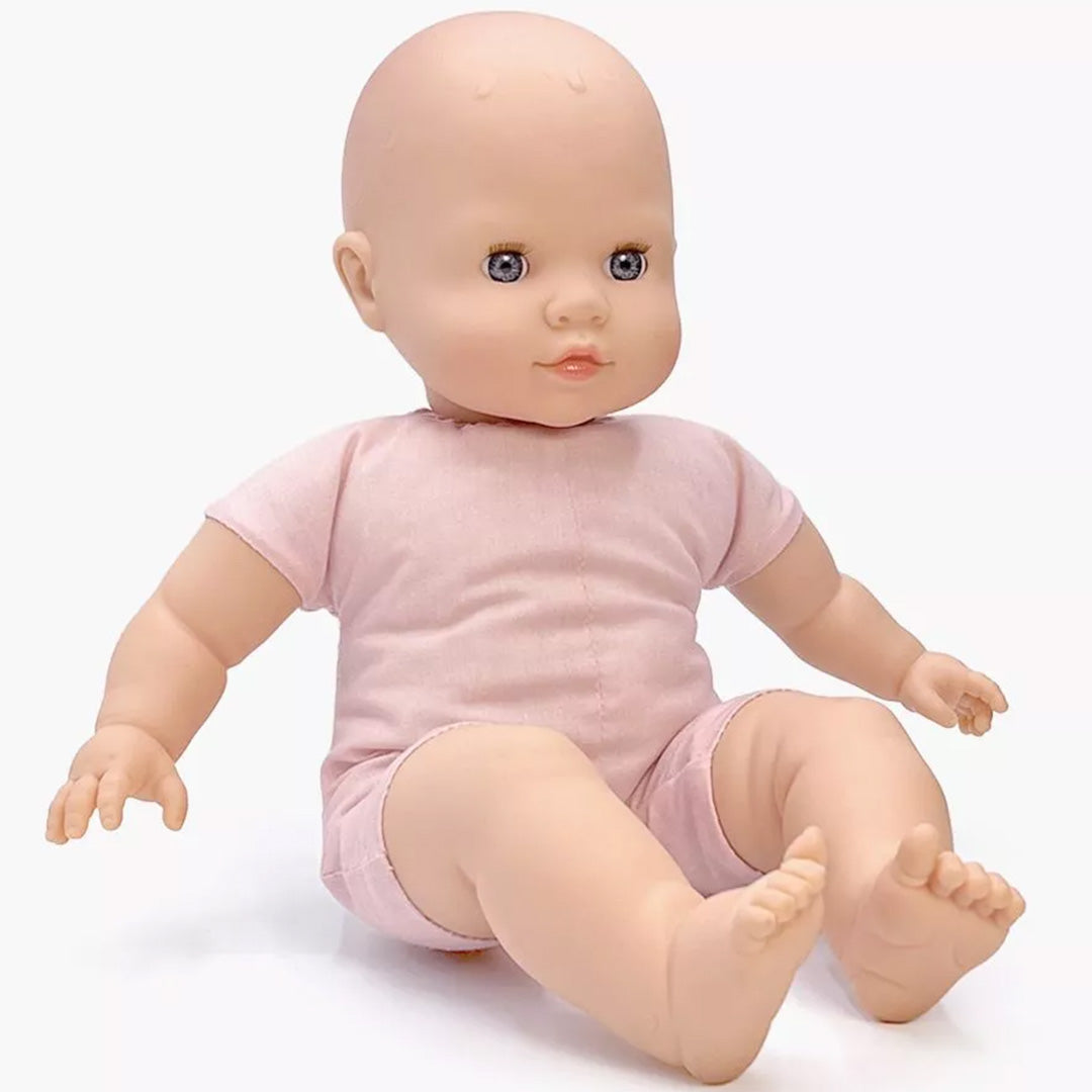 minikane babypop met open blauwe ogen en een roze pakje.