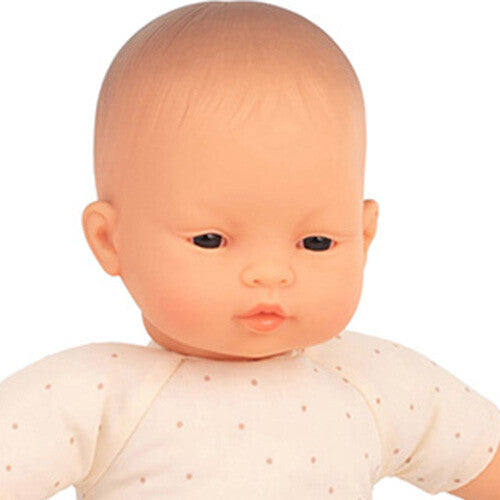 Detailopname van het gezicht en bovenlichaam van de babypop met Aziatische kenmerken.