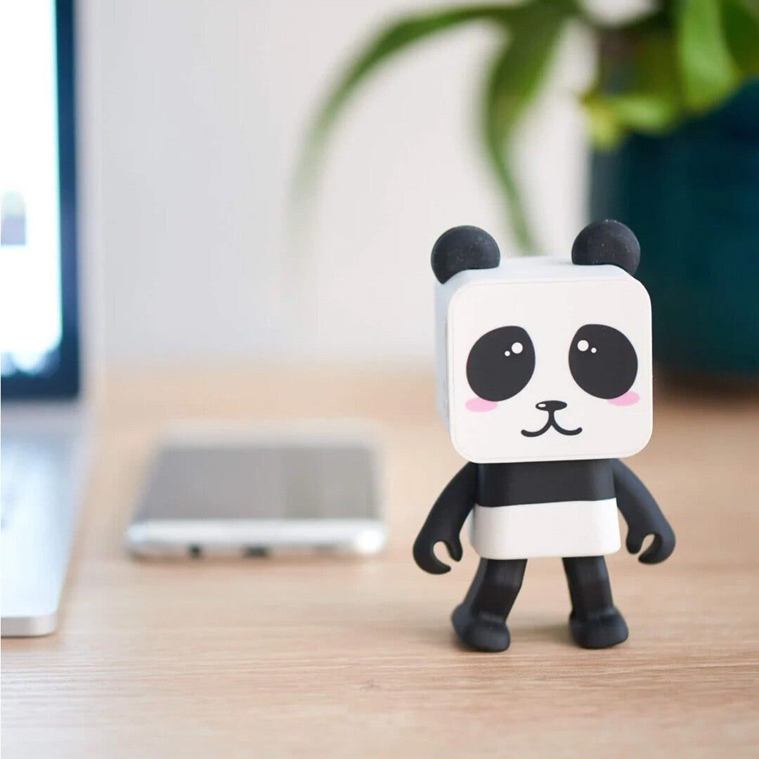 Mob panda bluetooth speaker op een houten bureau naast een laptop en smartphone.