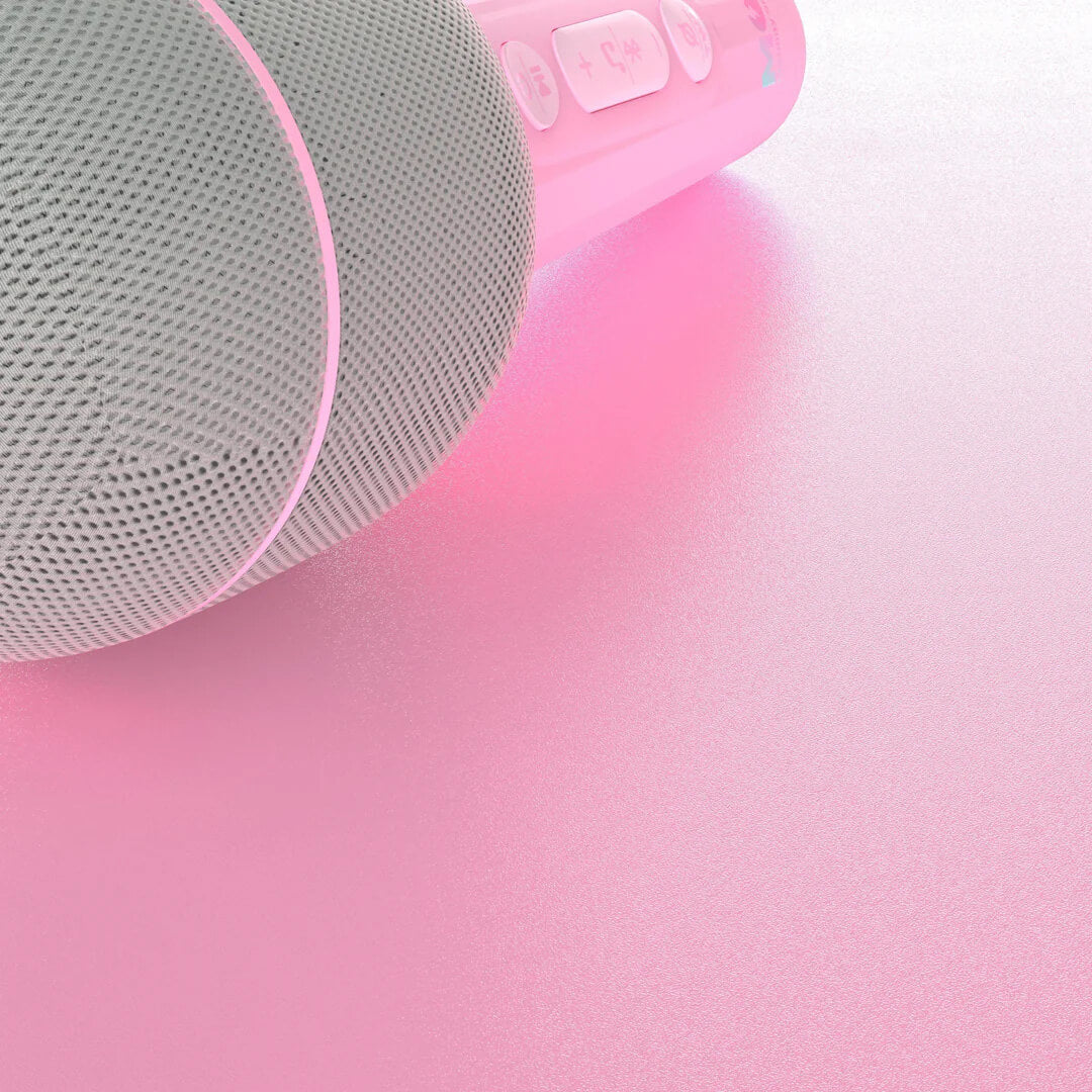 Detailopname van de roze karaoke microfoon op een roze ondergrond.