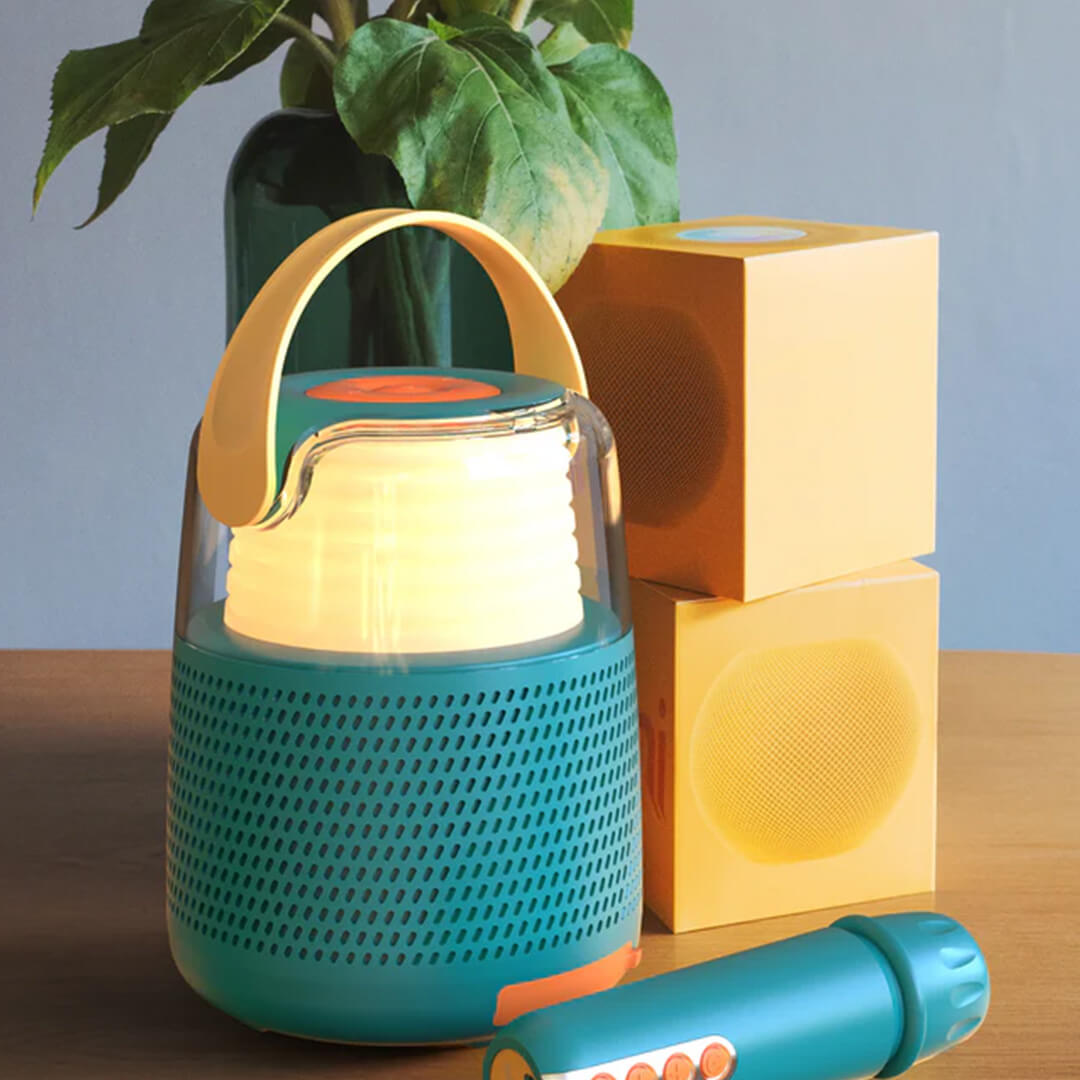 mob karaokeset in blauwgroen met warmgele verlichting en microfoon op een houten tafel.