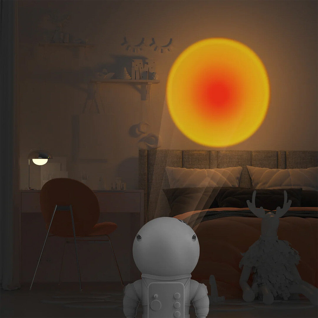 Het mob astronaut nachtlampje projecteert een oranje zonsondergang op de muur in een slaapkamer.