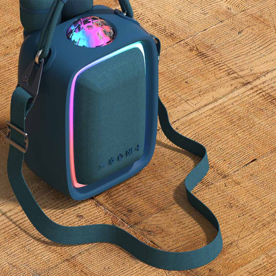 Mob karaokeset speaker met schouderband en regenboogverlichting op een houten ondergrond.