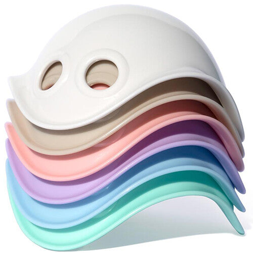 Een stapel Moluk Bilibo Mini activiteitenspeelgoed in verschillende pastelkleuren.