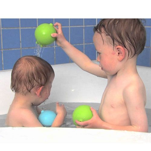 Twee kinderen spelen in bad met een blauwe en groene Pluï regenbal.