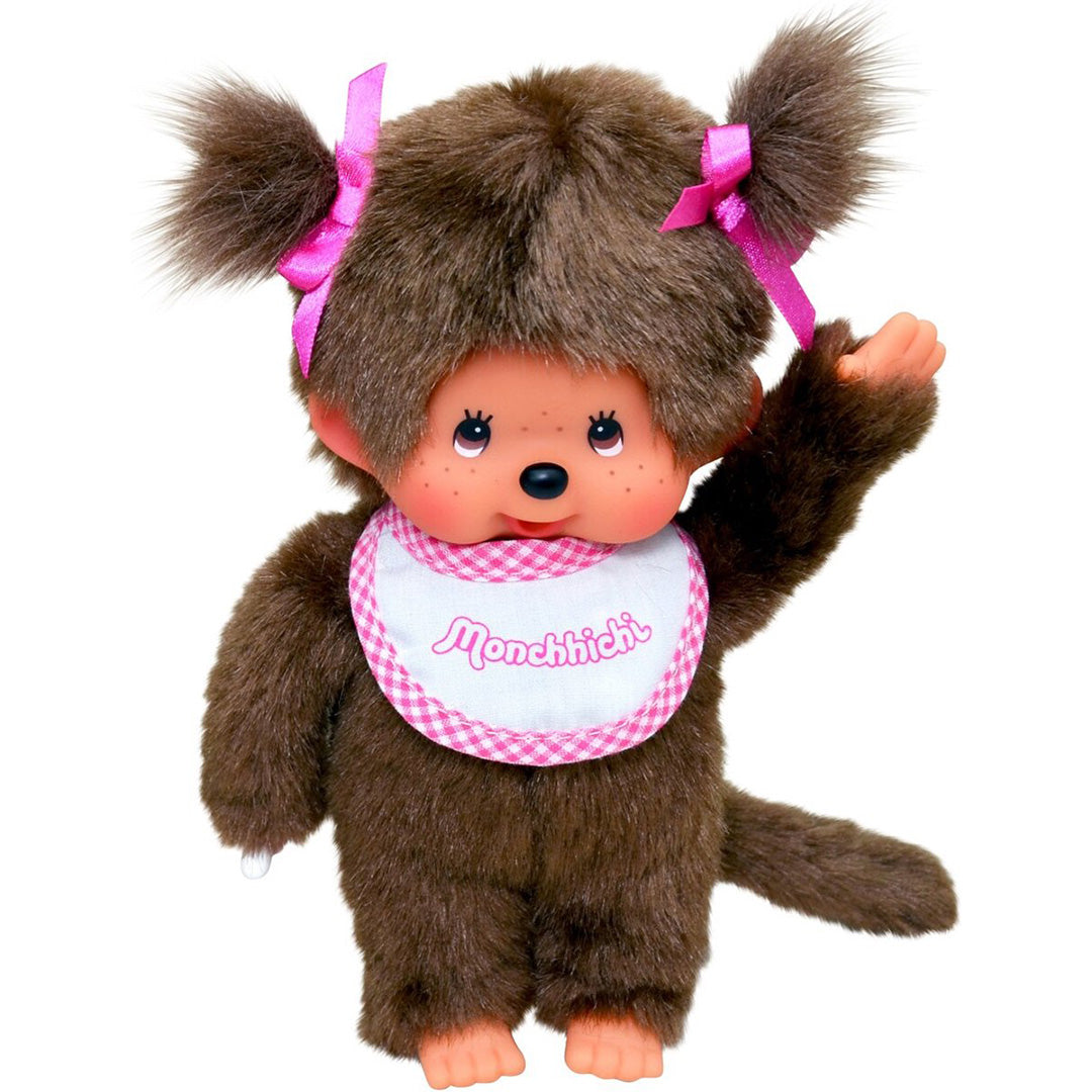 Monchhichi meisje pop met bruin pluche, roze strikjes en een geruite slab.