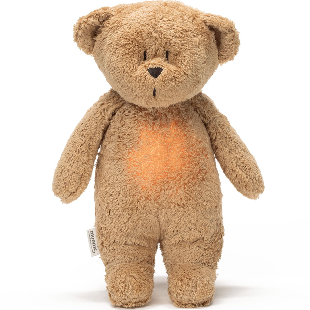 moonie pluchen knuffelbeer met nachtlamp en geluid, met een oranje gloed op de buik.