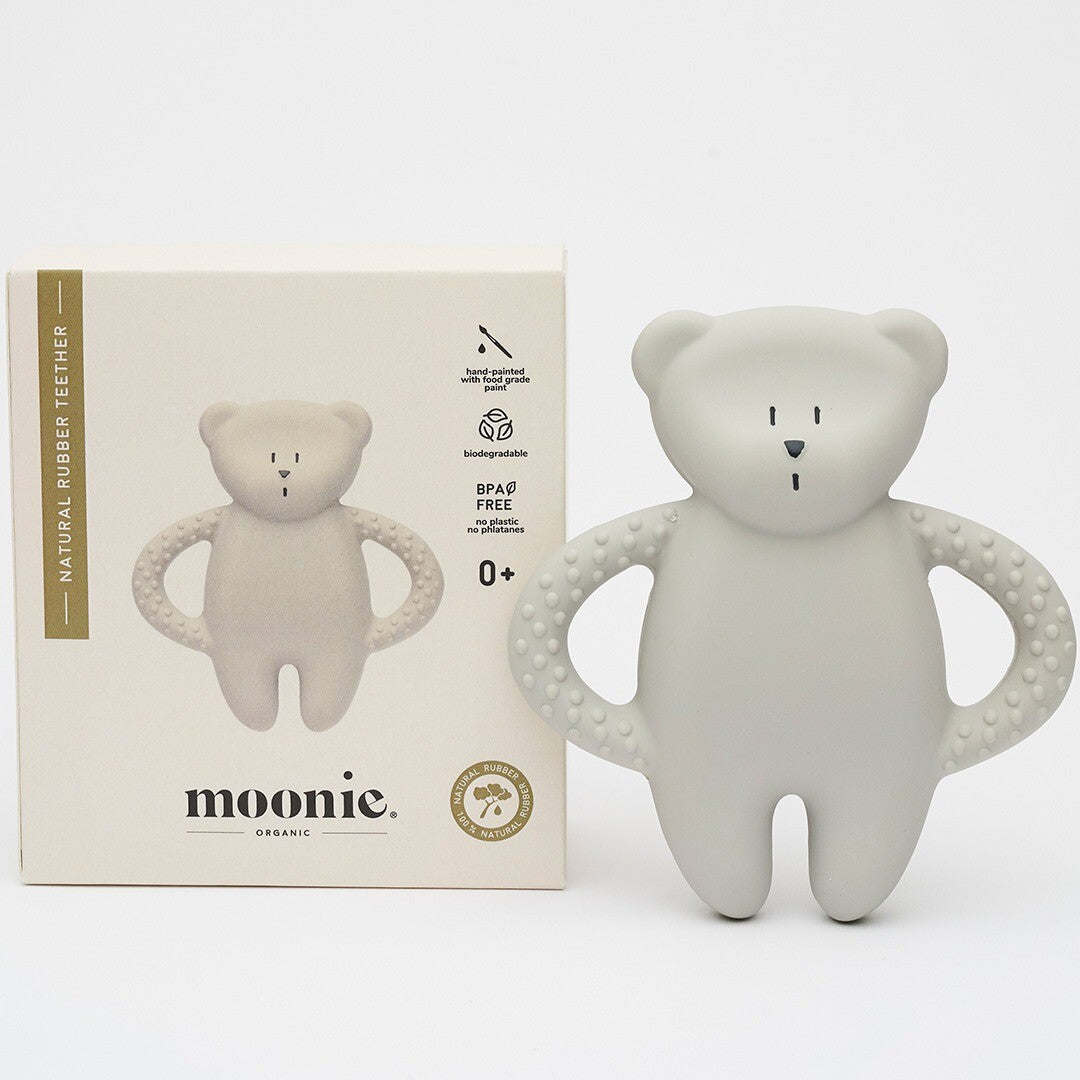 De moonie grijze rubberen bijtring in de vorm van een beer naast de productverpakking.