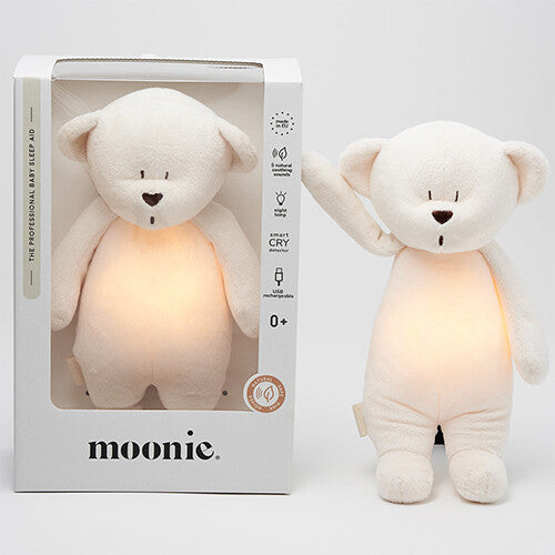 Moonie knuffelbeer met nachtlamp en geluid naast de productverpakking.