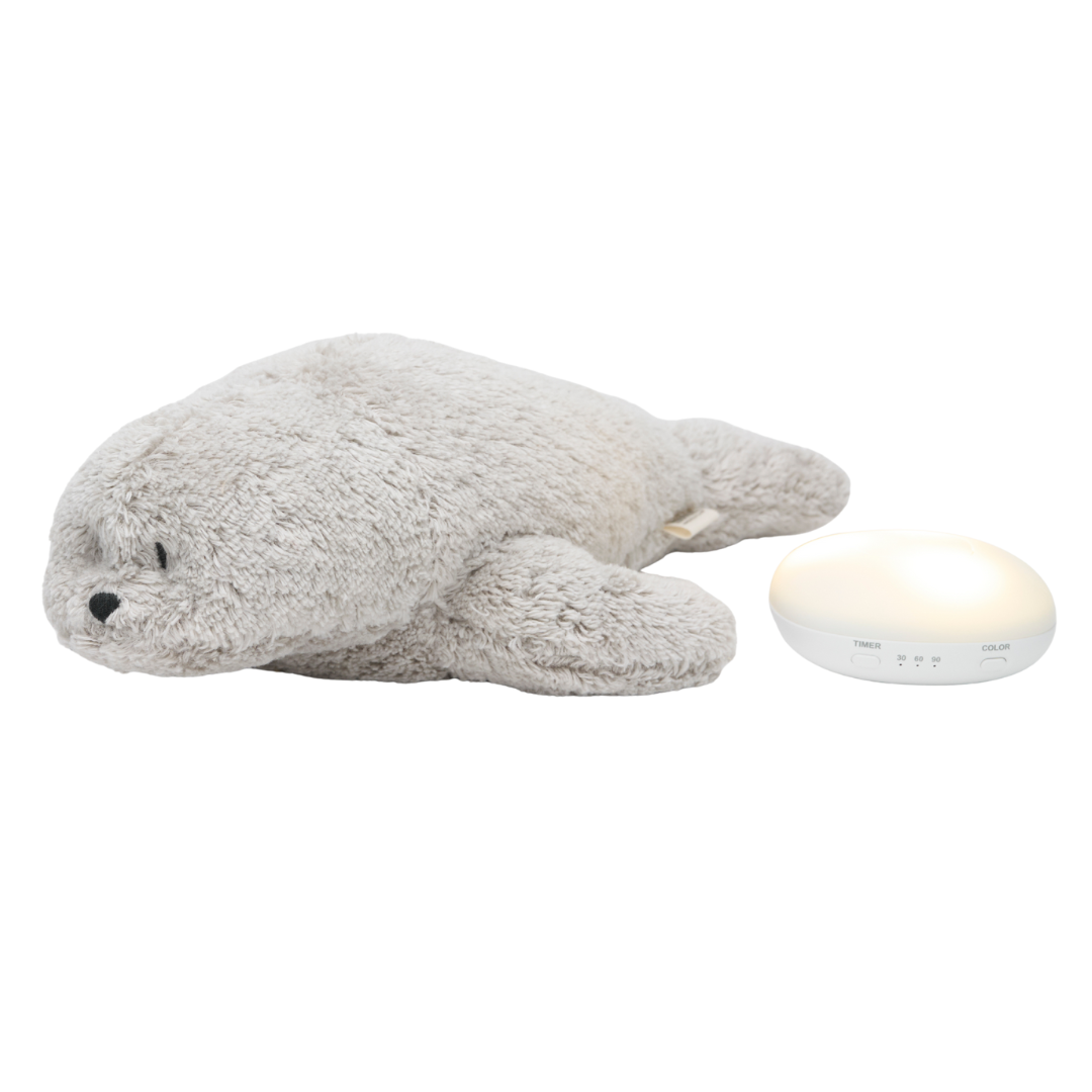 Moonie pluchen zeehond knuffel naast de losse nachtlamp en geluidsmodule.