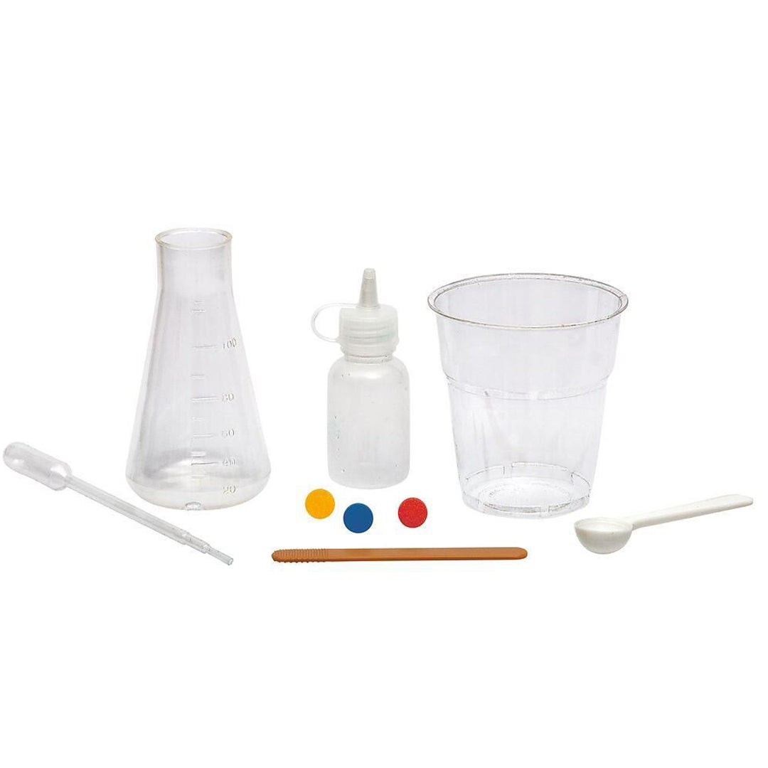 Diverse plastic onderdelen van de wetenschapsset, waaronder een erlenmeyer, flesje, beker, pipet, lepel, roerstaafje en kleurentabletten.