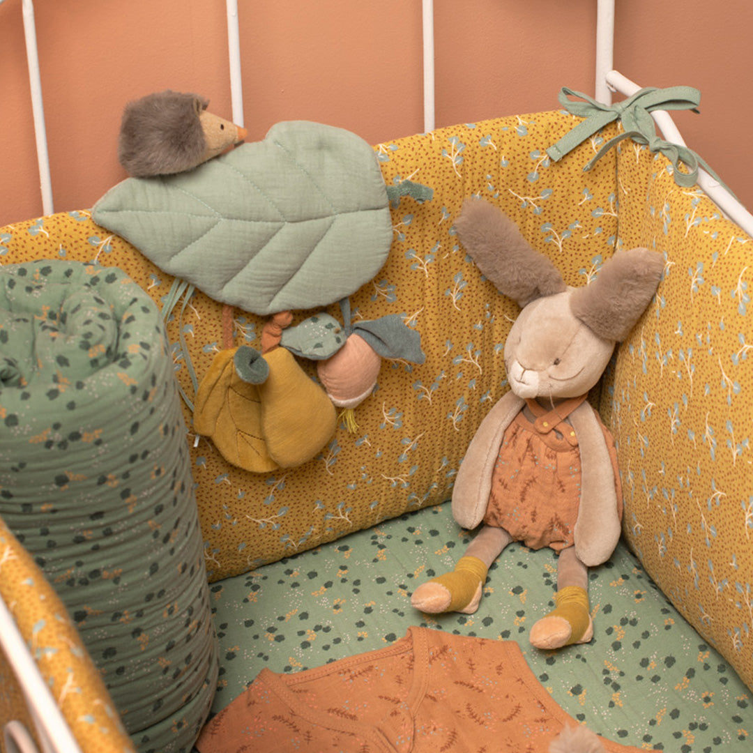 Moulin Roty babyspeelgoed activiteitenspeeltje in de vorm van een blad met egel hangend in een babybedje.