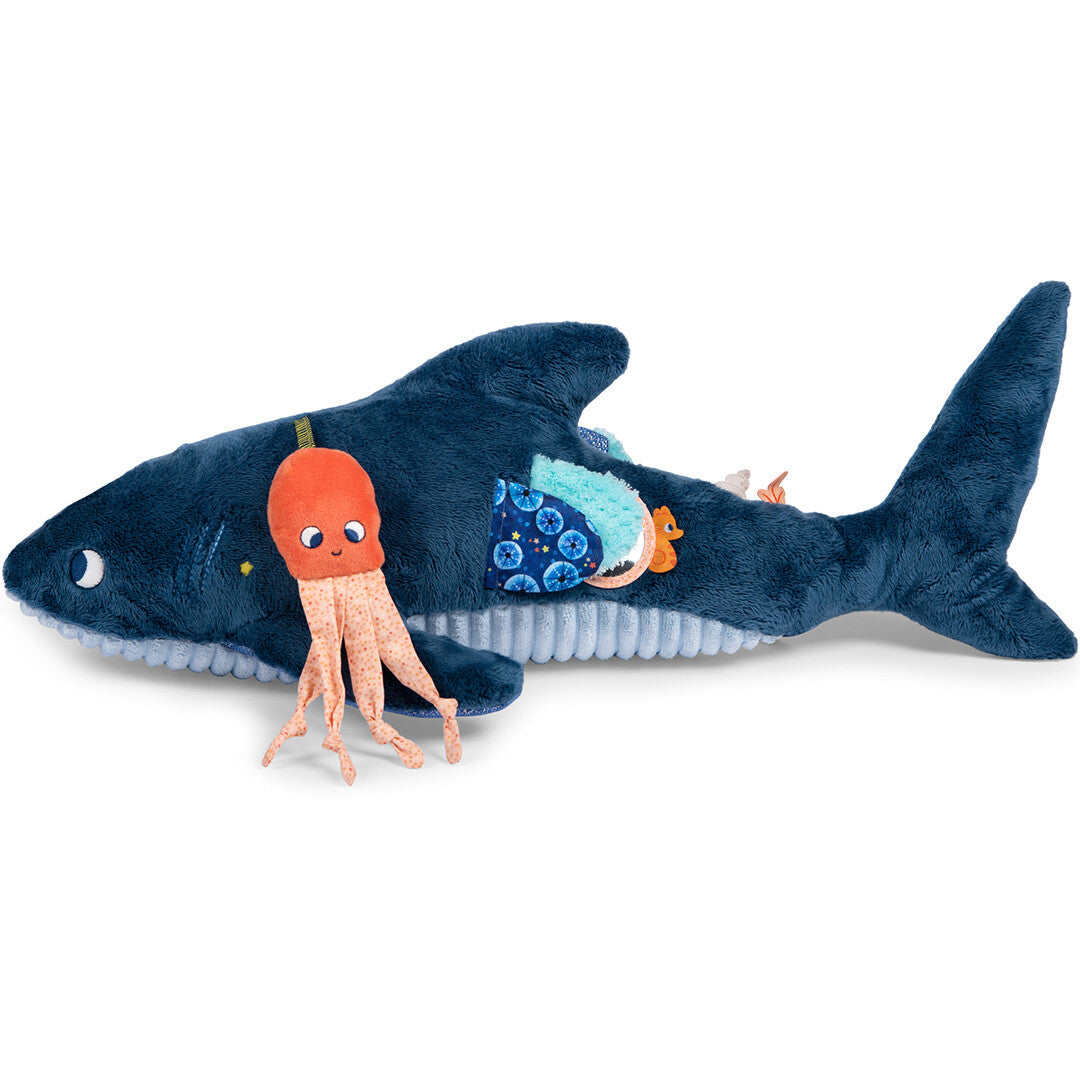 De blauwe pluchen haai activiteitsspeelgoed met een oranje octopus aan de zijkant.