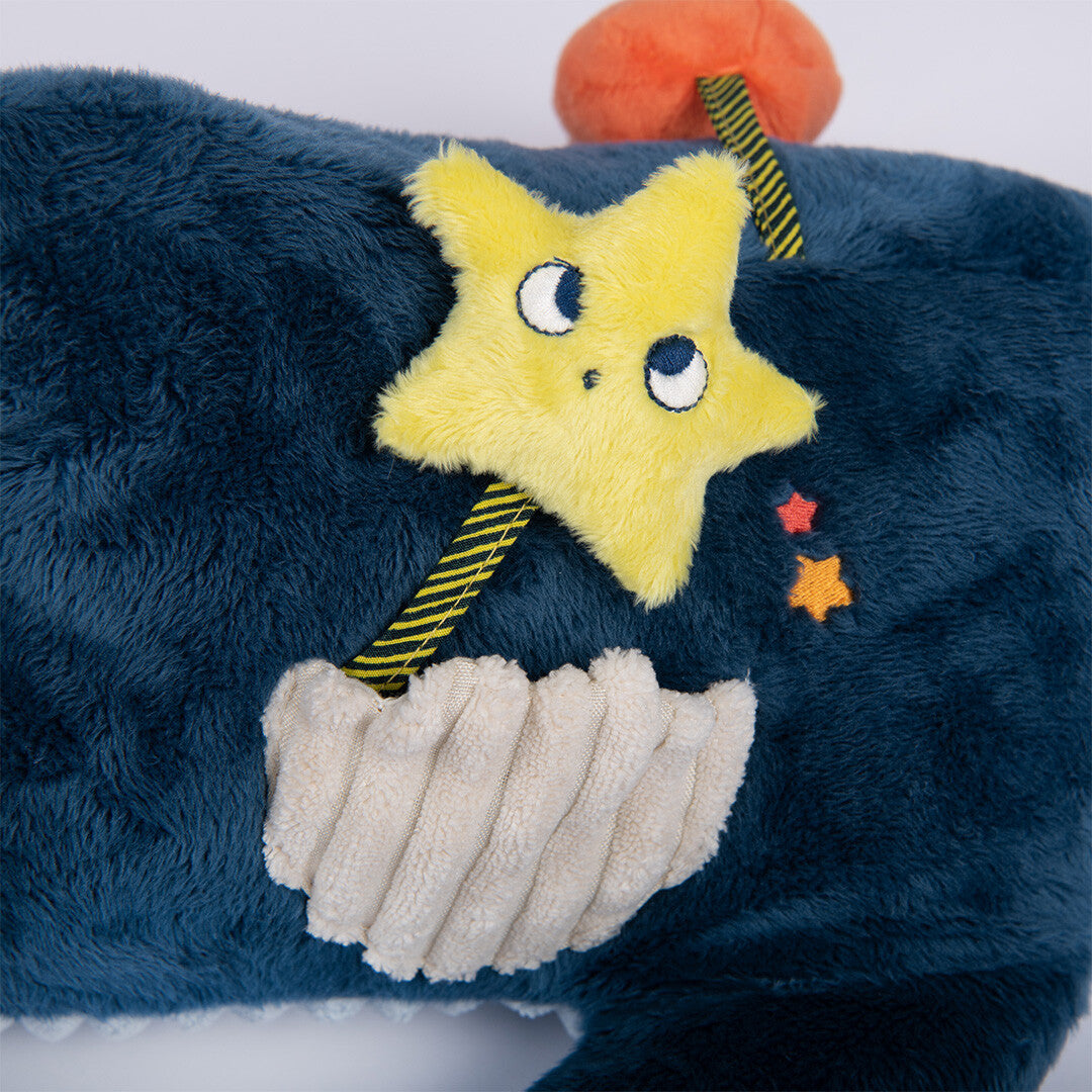 Detail van een gele pluchen zeester die uit een geribbelde schelp komt op de blauwe haai activiteitsspeelgoed.