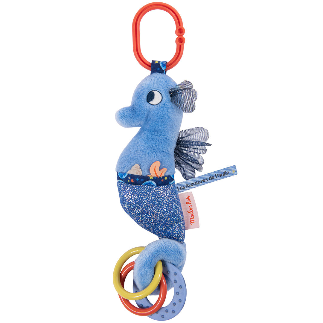 Moulin Roty blauw pluche zeepaardje activiteitenknuffel met oranje clip en rammelringen, recht van voren gefotografeerd.