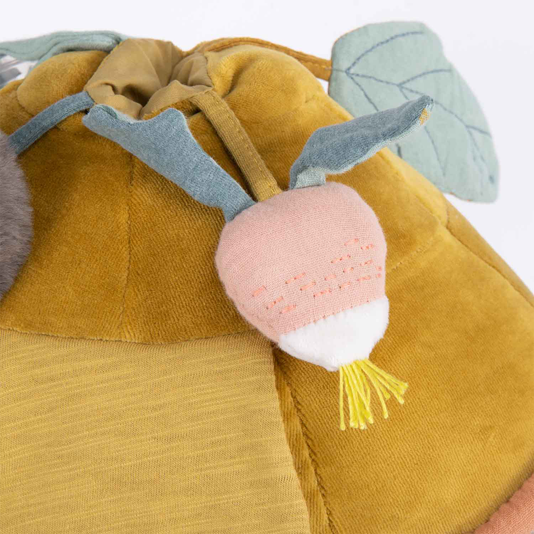 Detail van de roze radijs met groene blaadjes op de gele schild van de activiteitsschildpad.