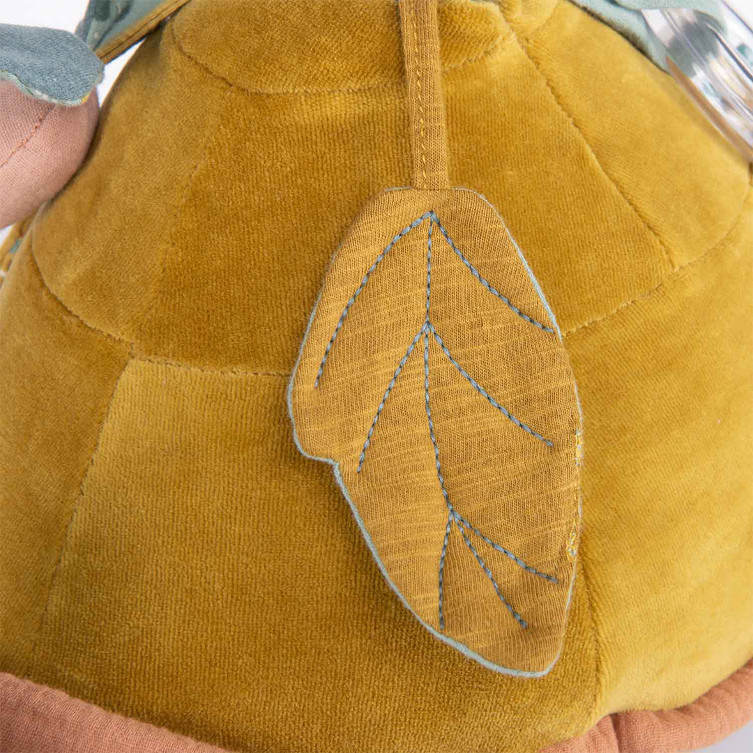 Detail van een geel stoffen blad met blauwe stiksels op de schild van de activiteitsschildpad.