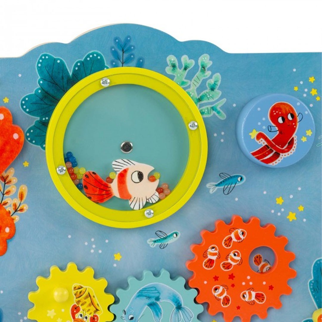 Detail van het Moulin Roty activiteitenpaneel met een gele rammelaar met vis en een oranje tandwiel met clownvissen.
