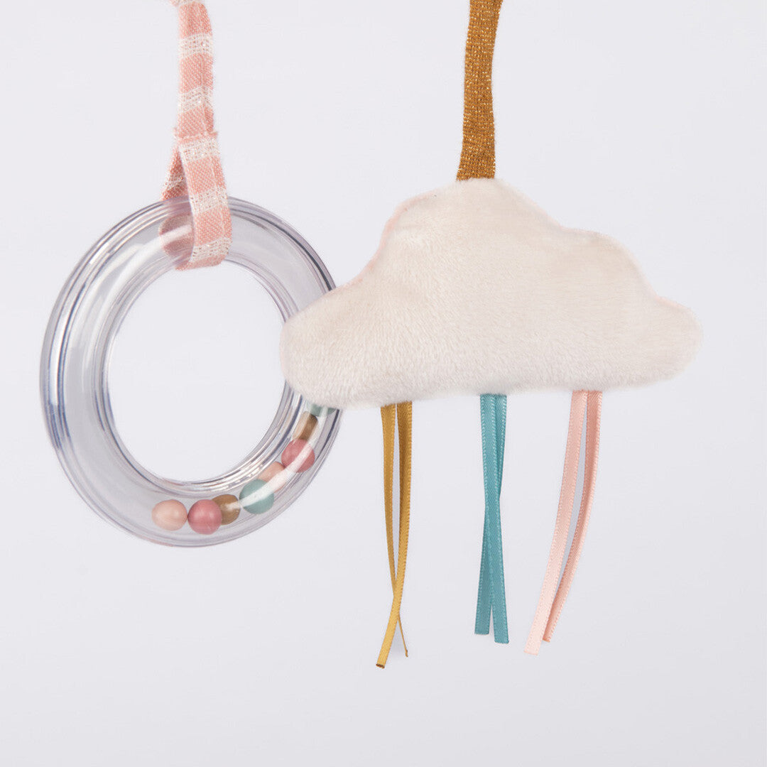 Detail van de activiteitenspiraal met een transparante rammelaar en een zachte wolk met gekleurde lintjes.