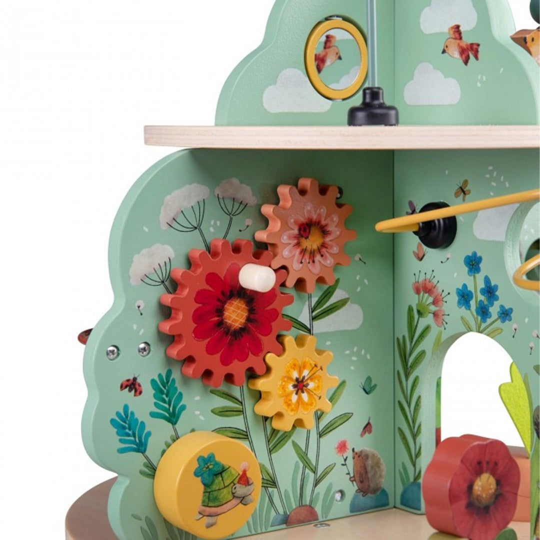 Detail van de activiteitentafel met kleurrijke draaiende tandwielen en bloemen.
