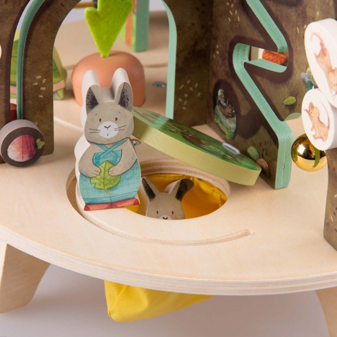 Detail van de activiteitentafel met een konijnenfiguur en een kleiner konijn in een hol.