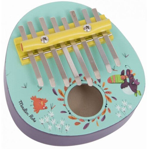 Moulin Roty lichtblauwe duimpiano kalimba met jungle thema, versierd met vogels en bladeren, schuin gefotografeerd.