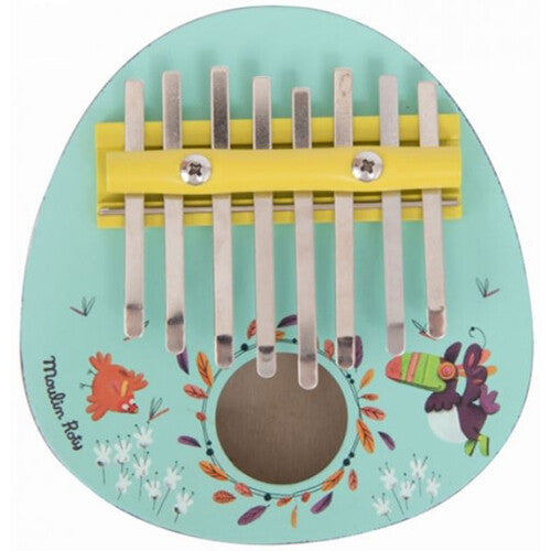 Moulin Roty lichtblauwe duimpiano kalimba met jungle thema, versierd met vogels en bladeren, van bovenaf gefotografeerd.