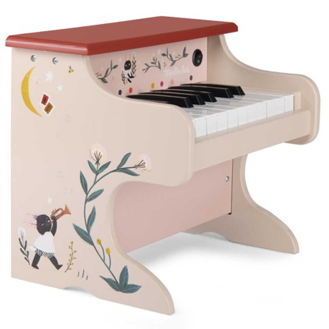 Moulin Roty elektronische speelgoedpiano met beige behuizing, rode bovenkant en illustraties van een kind, bladeren, maan en sterren.
