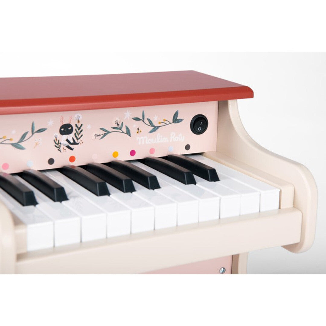 Detail van de toetsen en het geïllustreerde paneel van de Moulin Roty elektronische speelgoedpiano met aan/uit-knop.