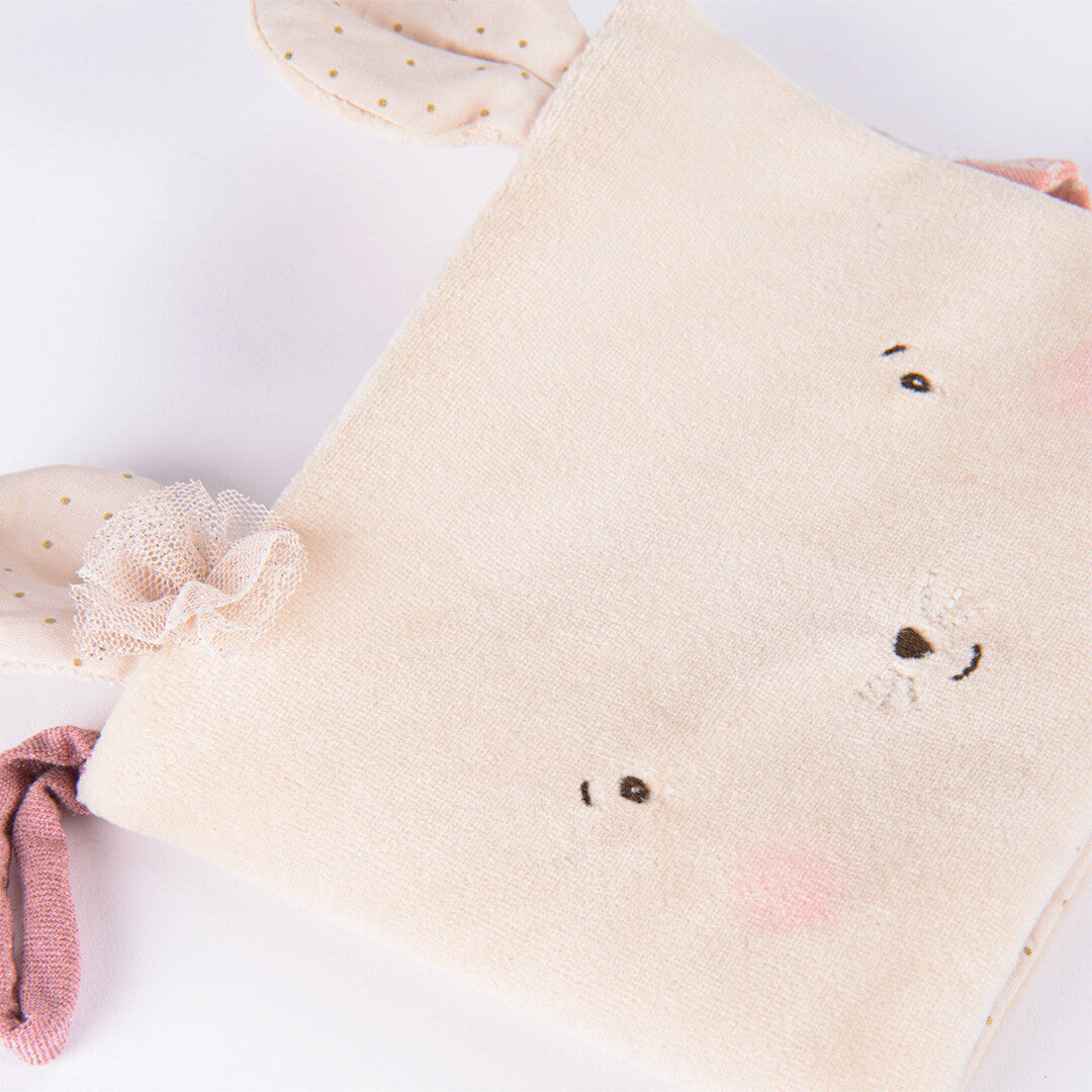Detail van het zachte beige muis baby fotoalbum met geborduurd gezicht en een oor met roze strik.